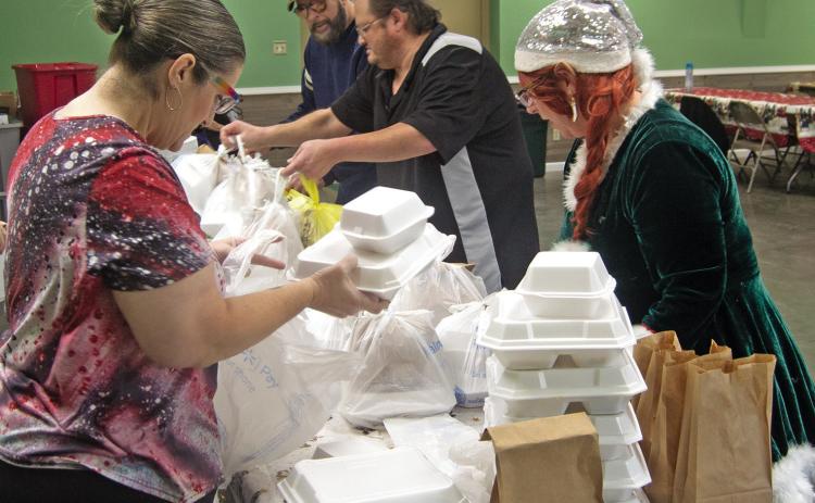 Volunteers prepare Christmas dinners for delivery to those unable to attend the Annual Community dinner at the 4-H building.