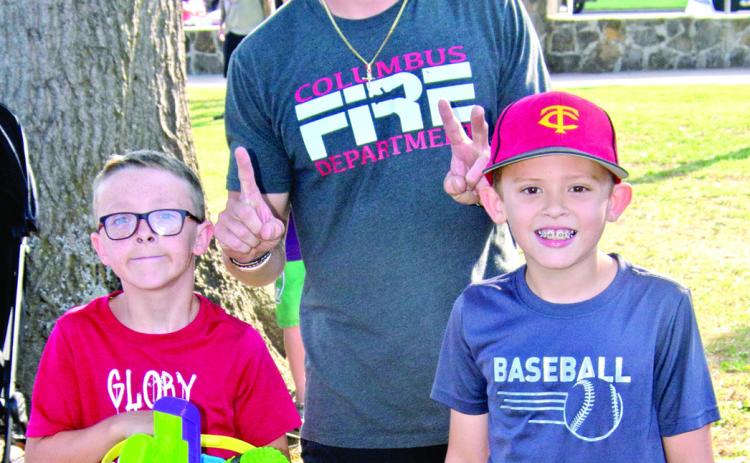 In Saturday’s Freedom Fest, sponsored by the Columbus Fire Department, Dayton Hughes and Jackson Harper won the boys six-11 years old sack race competition. Firefighter Austin Hoiser presented the prizes.