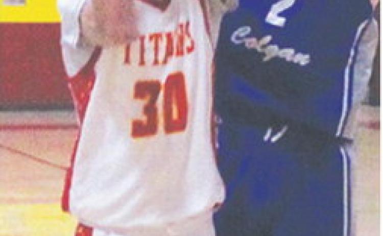 Drake Laurance, Titan Sophomore, shoots for two in the home opener against St. Mary’s-Colgan, Friday, at the CUHS Gym. Colgan Junior, Brady Crossland, defends the shot in the Panther win, 66-30.