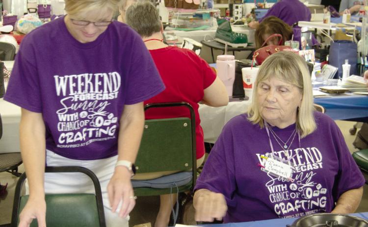 Kristi Fintner and Donna Campbell discuss photo placement on the page of a scrapbook. Everyone seems to be happy to offer advice when someone has a question.