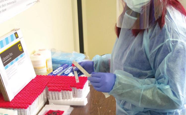 Preparing to test a patient at the Baxter Springs Ambulance office, Kate Sullivan, is suited up to protect herself and the person receiving the test. Every precaution has been taken to not spread the virus while giving the tests.