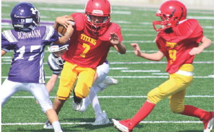 Mini Titan Briggs Johnson gets a block from Bodie Saiz on his way to the end zone for six of the 22 Columbus points scored in the victory over Pittsburg Ryan, 22-0, Saturday, at Hutchinson Field in Pittsburg. Courtesy Photo.