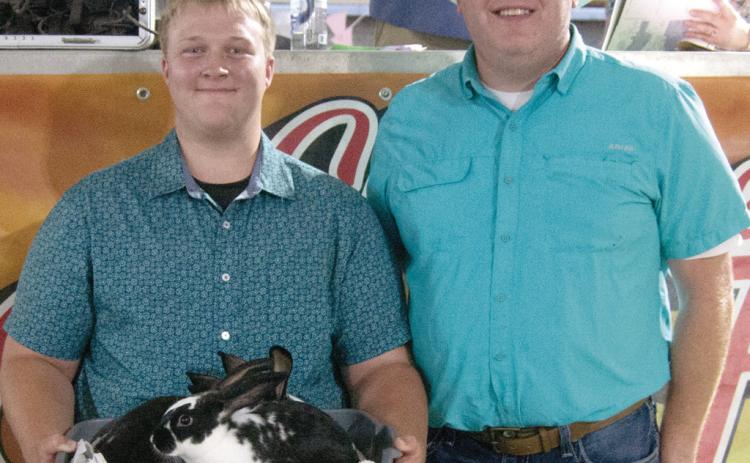 Glittering Stones 4-H member Joshua Brown, son of David and Serena Brown, showed the Grand Champion Rabbit colony and received a premium of $2,000 from Rainbow Solar.
