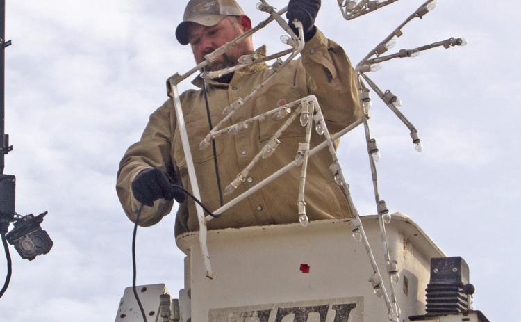 City workers Justin Rogers (pictured), Jared Kite and Kasie England took down the Christmas lights after the holidays. News Report photo by Shawn Churchill.