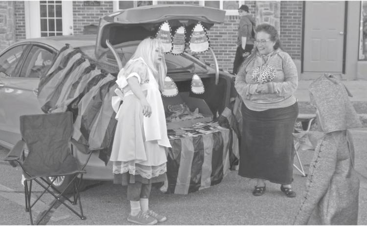 Many of the booths at the annual Halloween trunk or treat event decorated with creative costumes and banners. Alice and candy corn were part of this booth.