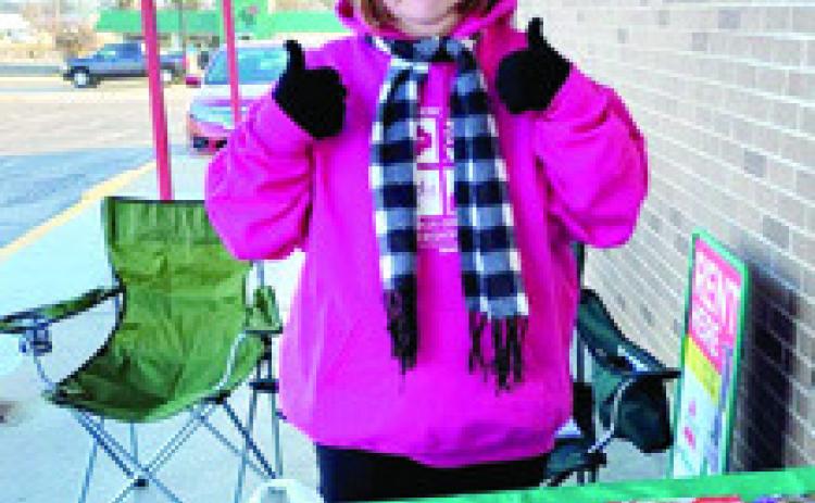 Local Girl Scout Izzy Manus has two thumbs up for cookie sales. Look for booths set up around Cherokee County to get your cookies. Courtesy photo.