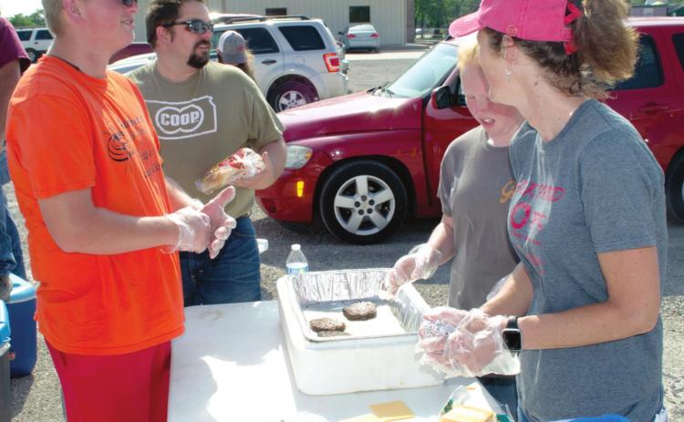 The weather didn’t put a damper on the recent Feed the Farmers event. Matt Case, chairman of the Chamber of Commerce Agriculture Committee and several members of the Shamrock 4-H Club turned out to fix hamburgers and drinks for farmers unloading at Farmers Coop. Wyatt Hall, Case, Gracie Jo Hall and Michelle Hamilton were preparing the burgers.