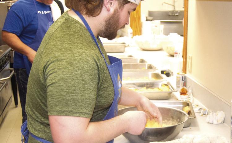 Chip Herrenbruck (back) and Peyton Herrebruck were on cooking duty. Peyton was coating the filets with batter before they went into the fryer.