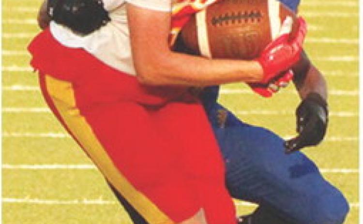 Gavin DePratt, Columbus Titan Senior, tries to escape the clutches of the Parsons Defender after making a catch during the four-team, Jamboree Scrimmage, Friday, at Girard. Parsons, Pittsburg, and Columbus varsity and junior varsity teams met their host team, Girard, at Frank Jameson Field for the scrimmage that has each team facing off in a series of plays before switching opponents throughout the event.