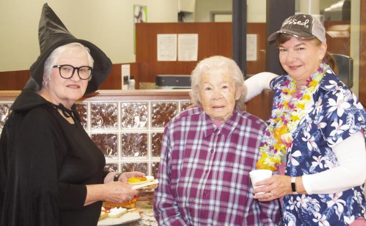 The staff and customers were enjoying the refreshing apple cider and cookies Friday during the annual Commerce Bank Customer Appreciation Day. Patty Dunnic was dressed as a witch, bank customer Eva Forkner was receiving refreshments from Janette Crain dressed for a Hawaiian trip. News-Report photo by Shawn Churchill.