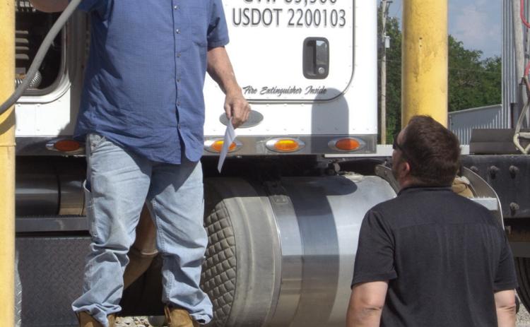 Fouts Farms Grain truck driver gives his burger order to Chamber Past President Matt Case. During the Chamber of Commerce Feed the Farmers semiannual program.