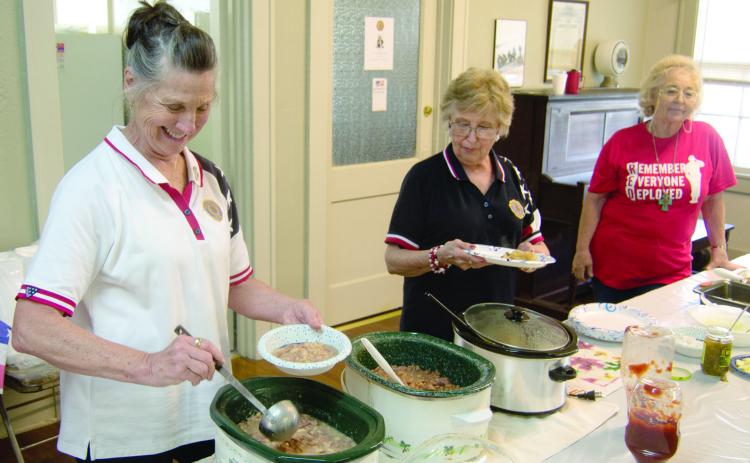 Sharon Day, Baxter Springs American Legion Auxiliary President, dips up beans at the recent bean feed. Assisting with the serving line were Sherry Shackleford and Justine Keenan.