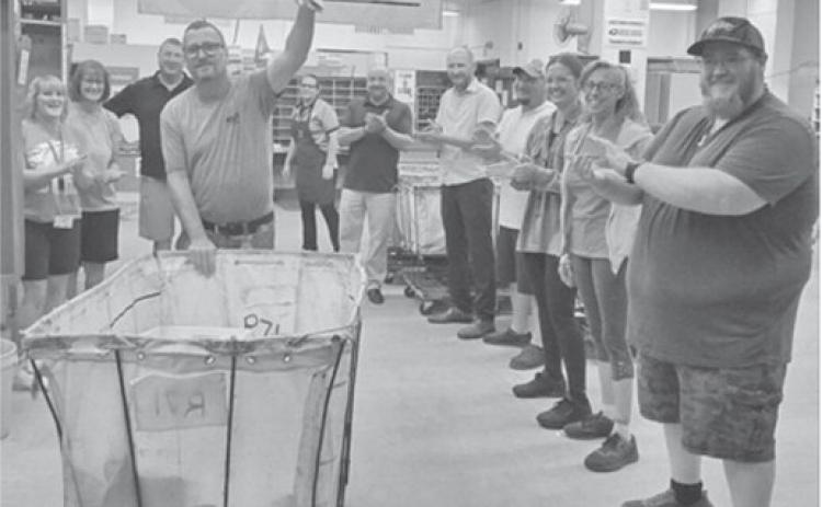 Pat York participates in the traditional “running of the gauntlet” at the Columbus Post Office. York is retiring after 26 years of service. Co-workers lined up to congratulate York on his accomplishments and to wish him well in his future endeavors. Courtesy photo.