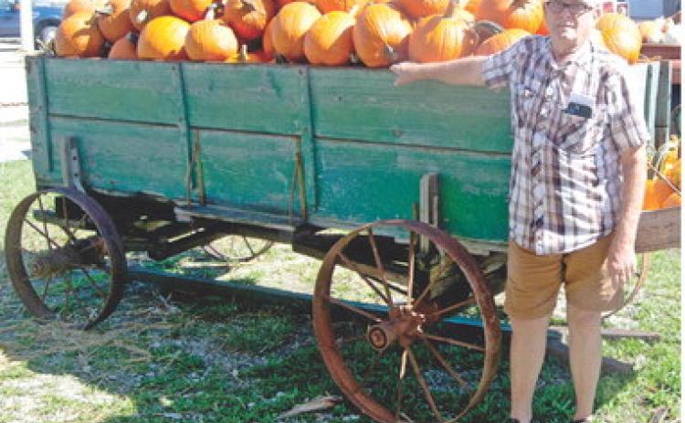 Columbus businessman Delbert Rowden stands next to a wagon load of pumpkins he brought into town for his final Pumpkin Patch. Delbert and Sheryl Rowden will no longer continue the Halloween.