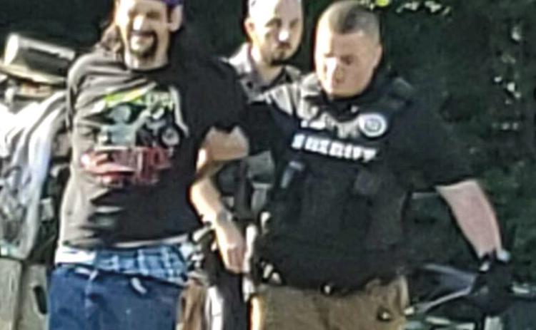 Sean Galloway surrendered to Cherokee County law enforcement after a short standoff Wednesday. He was escorted to the patrol car by Nate Jones. Courtesy photo.
