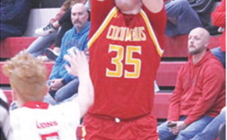 Titan Senior, Jett Tanner, makes one of his four, three-point shots to lead Columbus with 16 points in their 46-50 loss in Baxter Springs, Monday. Sophomore Logan Abbott defends for the Lions.
