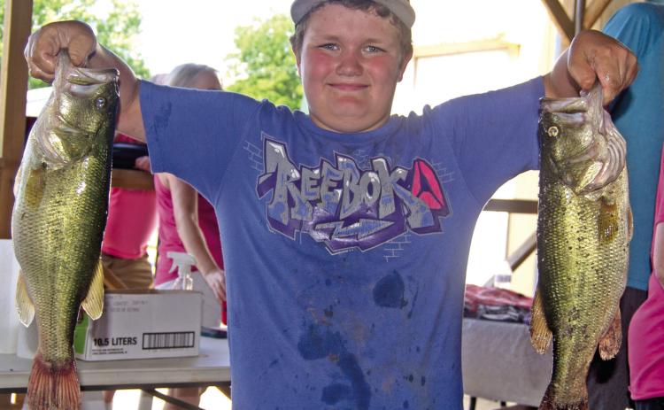 Had his catch been any bigger Kasden Fleshman would have needed help to lift his two big bass out of the creel. He was entered in the 49th Annual West Mineral Kids Fishing Tournament.