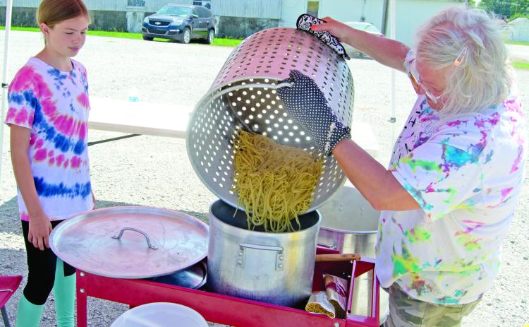 4-H’er Kate Martin watches as Rhonda Herrenbruck pours the spaghetti from the large cooking pot into the serving pan. Several different places were used to cook the spaghetti as the amount was overwhelming. The 4-H clubs are hoping to remodel the 4-H club building built in 1991.