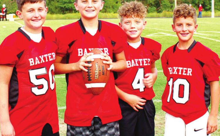 Up and coming football players help the Baxter Springs High School Lions by fetching water bottles, footballs and kicking tees during varsity games. Left to right: Weston Buck, Cole Parrish, Ethan McCoy, and Colt McCoy. Photo by Dee Riley.